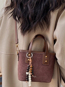 Sac seau matelassé en daim marron avec anses en cuir et breloque décorative