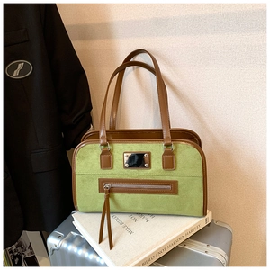 Close-up of vintage green suede tote bag with brown leather trim on silver suitcase