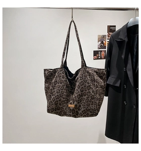Close-up of leopard print canvas tote bag with square yellow leather brand label