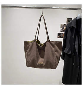 Close-up of brown canvas tote bag featuring classic plaid lining and our fave woven label