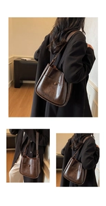 Detail view of large brown vintage leather bucket bag with metallic buckle and shoulder strap