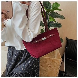 Dettaglio borsa tote in pelle scamosciata bordeaux con cinturino e fibbia in metallo