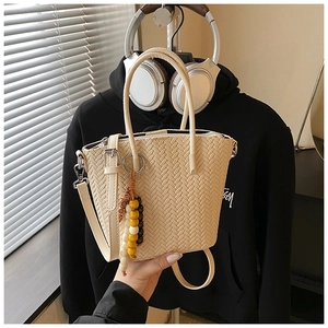 Detailed view of beige woven PU tote bag with rainbow bead charm and smooth zipper top