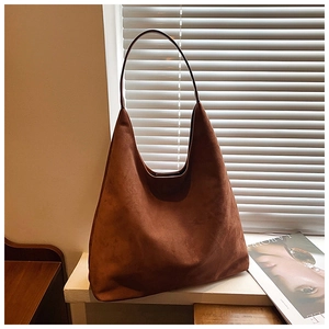 Detail shot of brown faux suede hobo tote bag featuring a spacious minimalist design