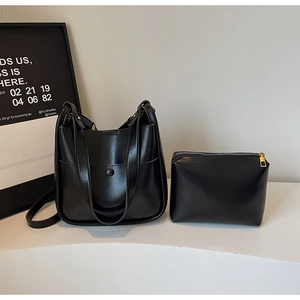 Detail view of black PU leather bucket bag set with matching zipper pouch and gold hardware