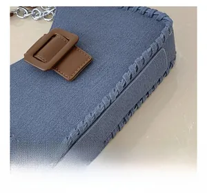 Détail du sac bandoulière en toile grise avec bords tissés et accents en cuir marron