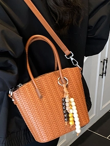Brown woven crossbody bucket bag for women with decorative beaded tassel charm