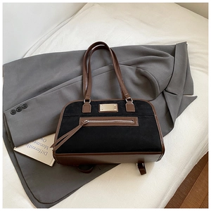 Détail du sac cabas en nubuck noir avec bordures en cuir marron et finitions dorées