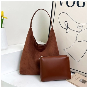 Detail of dark brown matte tote bag with matching leather pouch on a white pedestal