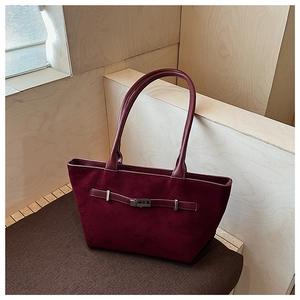 Dettaglio borsa tote in pelle scamosciata bordeaux con fibbia argento e texture opaca