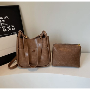 Detail view of brown bucket bag with contrast stitching and inner zipper pouch
