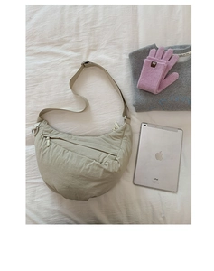 Detail of beige crescent crossbody bag with nylon texture and daily commute essentials