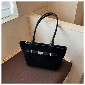 Dettaglio borsa tote in pelle scamosciata nera con fibbia in metallo e tracolla in pelle
