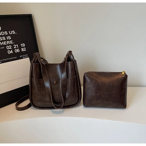 Detail view of a vintage dark brown bucket bag set with textured leather and inner pouch