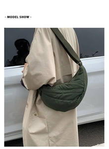 Close-up of a dark green crescent moon crossbody bag with quilted nylon texture