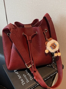 Vintage burgundy bucket bag with drawstring closure and cute charm accessory