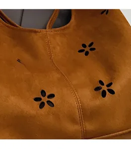 Détail du daim marron avec motif floral ajouré et finitions de coutures artisanales