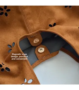 Détail du fermoir magnétique et motif floral découpé au laser sur sac cabas marron