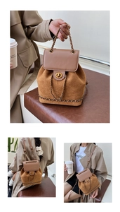Detail of a brown patchwork bucket backpack featuring gold chain handle and twist lock