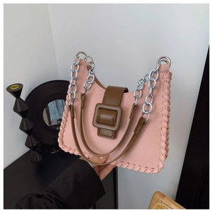 Détail du sac à main en toile rose avec bords tissés et bandoulière en chaîne argentée
