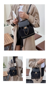 Close-up of black suede backpack featuring vintage gold chain and turn-lock closure