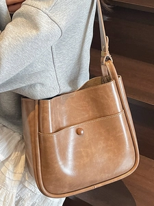 Retro brown leather bucket bag with white stitching and crossbody strap for women