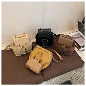Detail view of four mini bucket backpacks in beige, black, brown and yellow suede