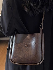 Retro dark brown leather bucket bag with large capacity and vintage metal buckle detail