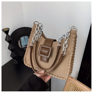 Détail du sac à main en toile kaki avec rabat en cuir marron et chaîne en métal