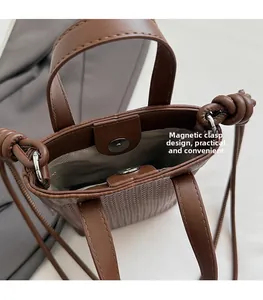 Detail of the magnetic buckle closure on a brown woven texture mini crossbody bag
