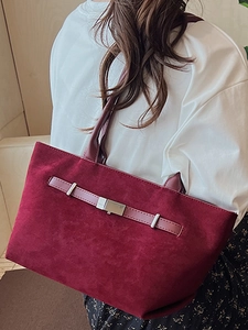 Borsa a secchiello bordeaux in finto camoscio con fibbia argento indossata da una modella