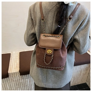 Close-up of vintage brown suede and leather backpack with gold chain and twist lock