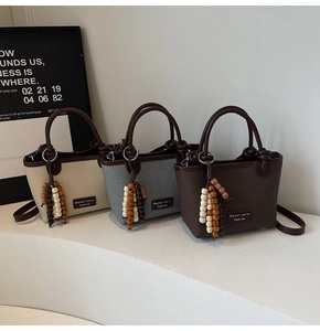 Three minimalist woven bucket bags in beige, blue, and coffee with wooden bead charms