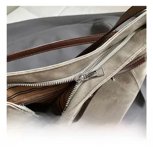 Detail view of khaki tote bag with silver zipper and brown striped fabric lining