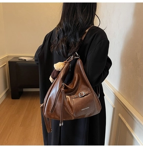 Détail du sac cabas vintage marron avec un pendentif ours en peluche élégant