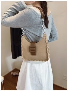 Détail du sac sous le bras en toile avec surpiqûres et bandoulière chaîne en cuir