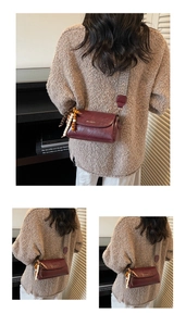 Détail du sac bandoulière en cuir bordeaux avec sangle bohème et accessoire en perles