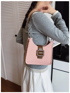 Détail du sac bandoulière rose avec boucle marron et texture tissée latérale pour femme