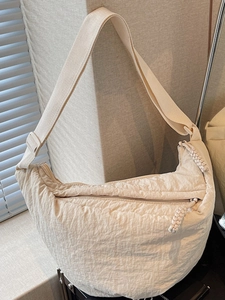 Minimalist beige pleated crescent crossbody bag with adjustable wide strap and zip closure