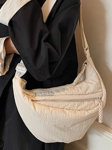 Minimalist beige crescent crossbody bag with woven zipper details for women