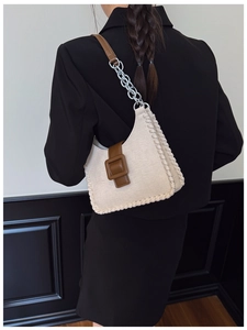 Détail du sac hobo avec texture en toile, garniture en cuir et bandoulière en chaîne métal