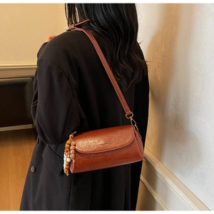 Gros plan sur le sac bandoulière en cuir marron vintage avec gland en perles