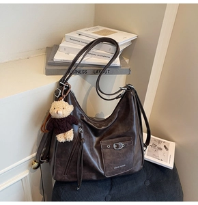 Vue détaillée du grand sac cabas marron en cuir souple avec zips et pendentif ours