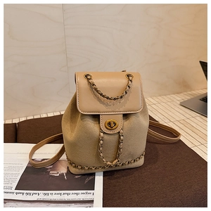 Detailed close-up of khaki suede bucket bag with gold chain strap and metal swivel lock