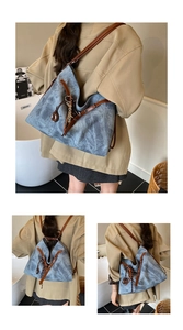 Detail showing the drawstring closure and brown leather straps of the large blue tote bag