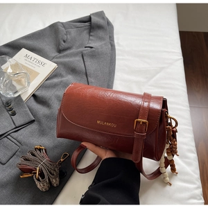 Détails du sac rétro marron avec texture de cuir et sangle pied-de-poule