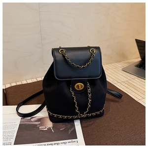Detail of black faux leather bucket backpack with gold chain handle and twist lock closure