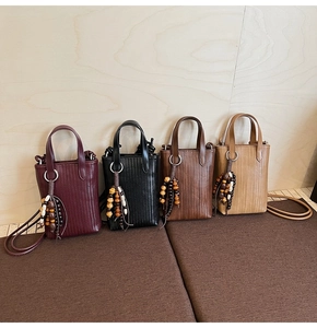 Detail showing four colors of mini woven tote bags with decorative wooden bead charms