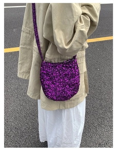 Detail einer lila Pailletten Umhängetasche getragen von einem Model über einer Khaki-Jacke