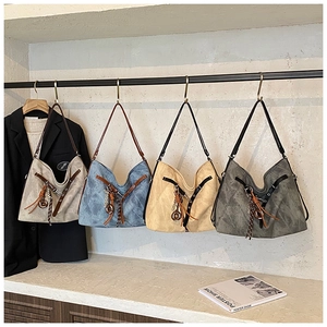 Detailed view of large vintage tote bags in four colors hanging on a metal rack
